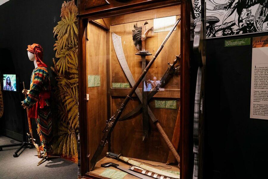 Allestimento della mostra Sandokan - Manichino in costume tradizionale accanto a una teca con armi autentiche del popolo Dayak